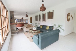 A spacious living room with a sofa, coffee table, and a fireplace. - Cozy 12BR House with Pool in Pachacamac (Pachacámac)