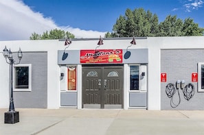 A building with a sign for 'Alberto's Mexican Food' and two Tesla electric vehicle charging stations.
