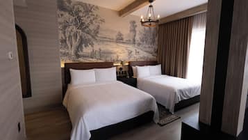 Una habitación de hotel con dos camas, un mural grande en la pared, una araña y una ventana con cortinas.