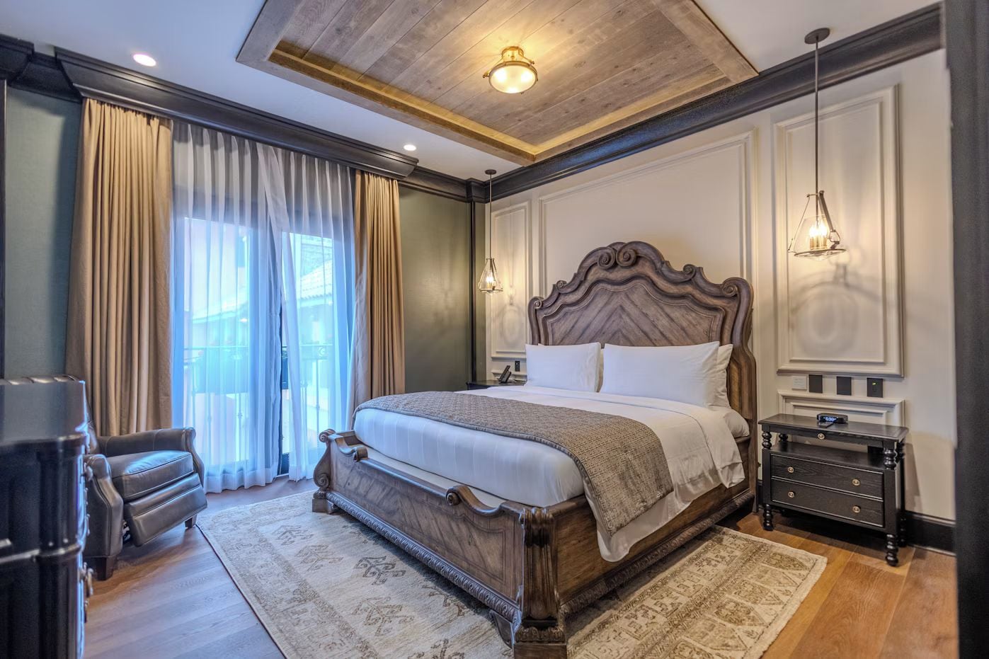 A bedroom with a large bed, a desk, and a chair.