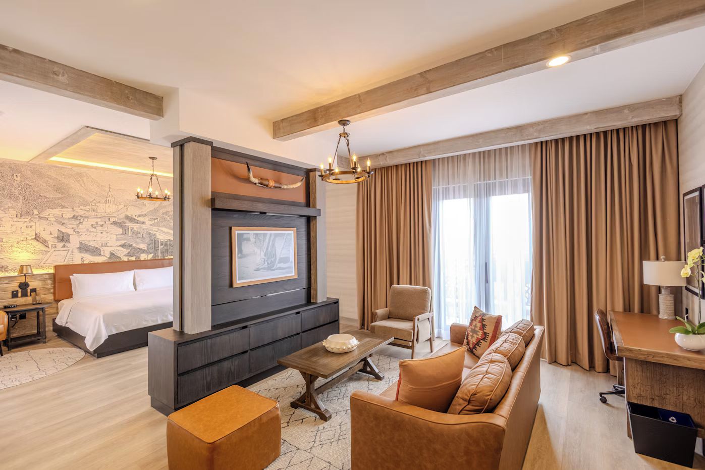 Una habitación de hotel moderna con una cama grande, un sofá, un escritorio y una chimenea.
