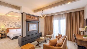 Una habitación de hotel moderna con una cama grande, un sofá, un escritorio y una chimenea.