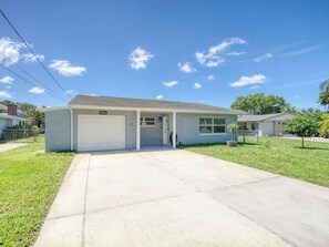 A single-story residential house with a garage, a front lawn, and a clear sky. - 3BR Waterfront + Private Pool | Port Richey (Port Richey)