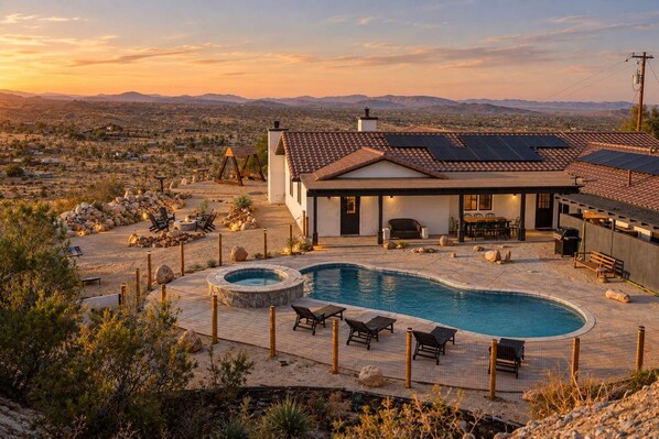 Ein Wohnhaus mit Swimmingpool, Sitzgelegenheiten im Freien und Blick auf die umliegende Landschaft.
