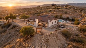 Ein Haus mit Terrasse, Swimmingpool und Blick auf die umliegende Wüstenlandschaft.