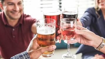 En gruppe mennesker skåler med øl og vin.