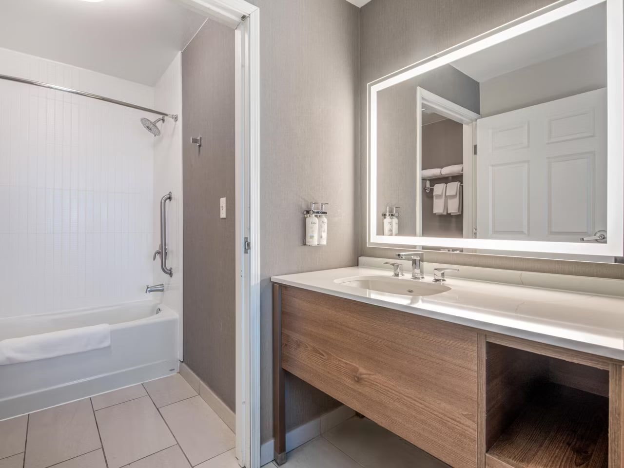 Un baño moderno con bañera, tocador con espejo y zona de ducha.