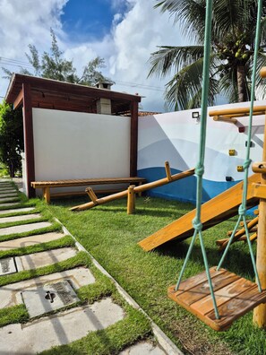 A playground with a swing set, a slide, and a climbing structure.