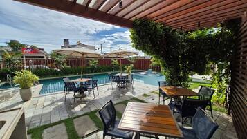 Área externa com varanda, piscina, assentos e vista para o bairro.
