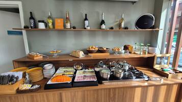 Un comptoir de buffet proposant une variété de plats, d’ustensiles et de condiments.