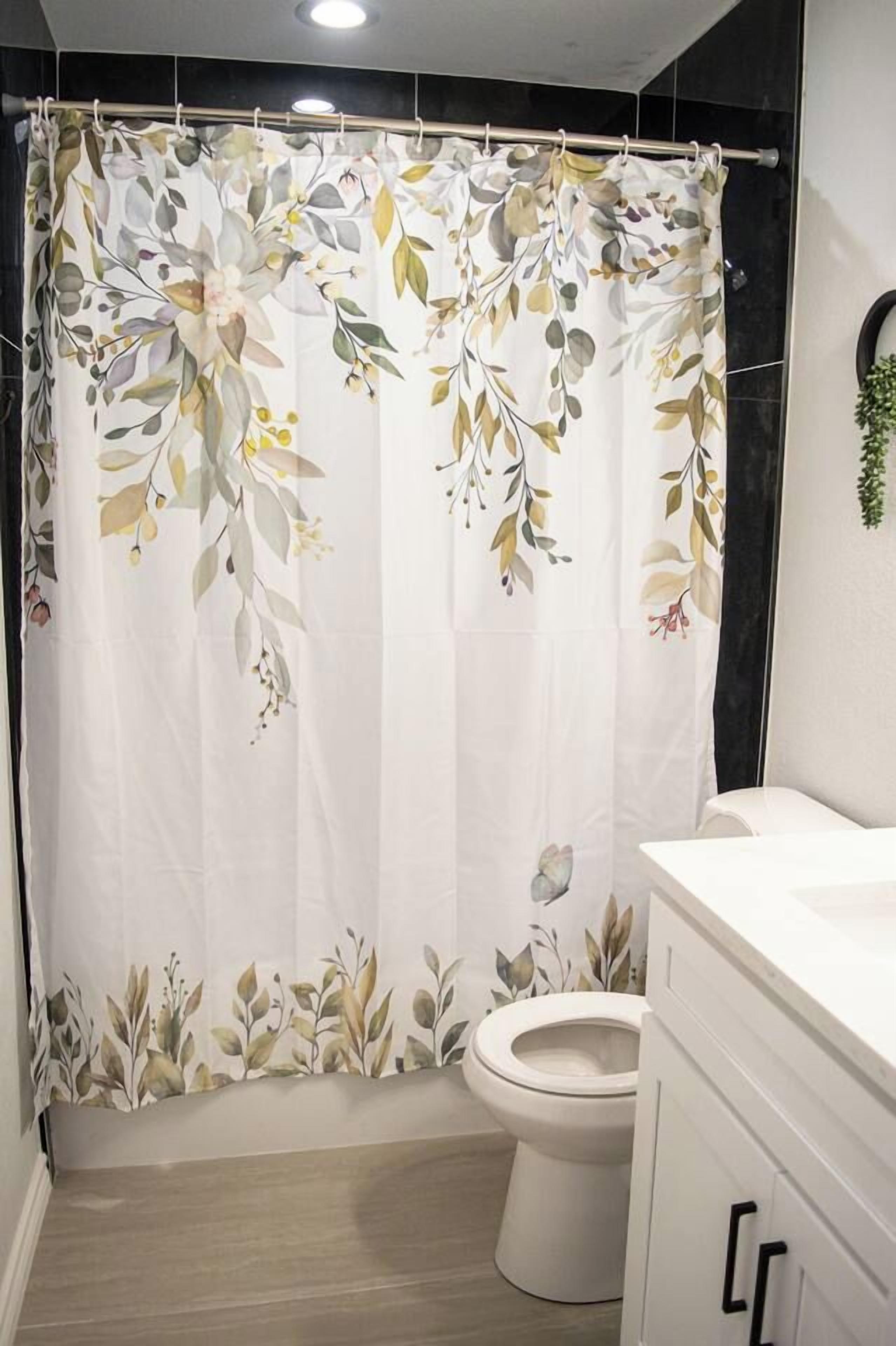 A bathroom with a shower curtain featuring a floral pattern, a toilet, and a white cabinet.