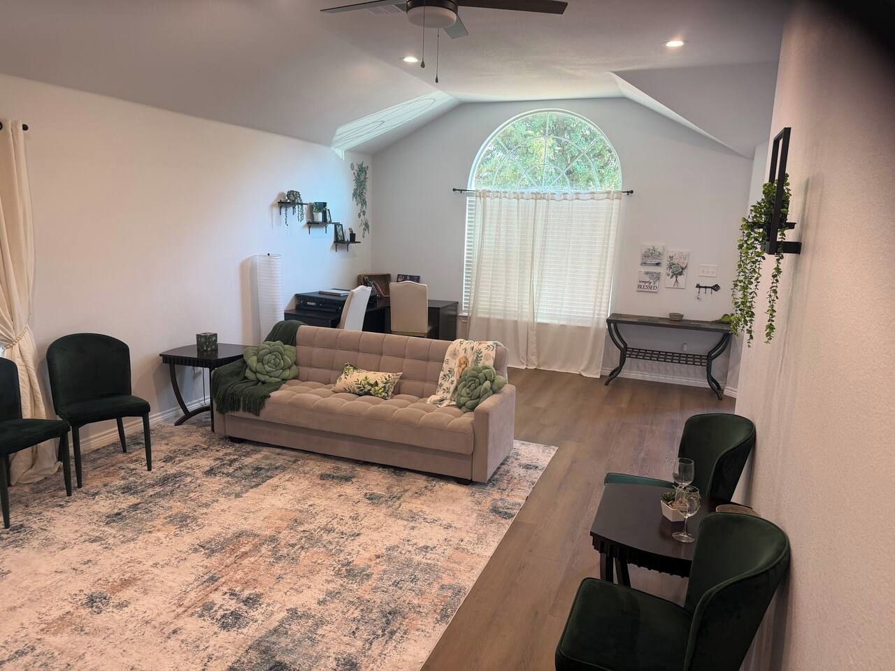 A living room with a sofa, chairs, a coffee table, and a dining area with chairs and a table.