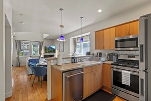 Cocina moderna con una isla central, electrodomésticos de acero inoxidable y armarios de madera.