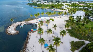 A coastal property with a marina, beach, and palm trees.