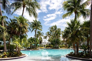 A swimming pool surrounded by palm trees and a clear sky.