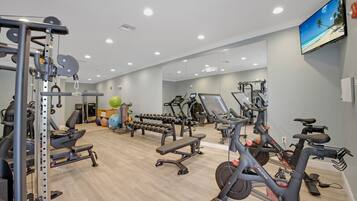 A gym with various exercise equipment, including treadmills, stationary bikes, and weight machines.