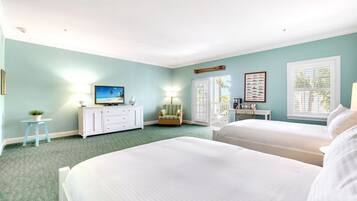 A bedroom with two beds, a dresser, a television, and a window with blinds.