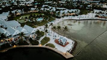A coastal resort with multiple white buildings, a sandy beach, and a calm water body.