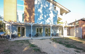 A covered patio area with outdoor seating and a view of a building with large windows. - 3 bedroom nice apartment in Oliveto Citra (Oliveto Citra)