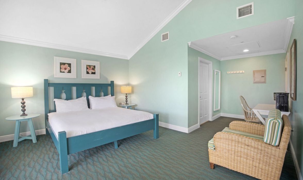 A bedroom with a bed, two bedside tables, a chair, and a small table.