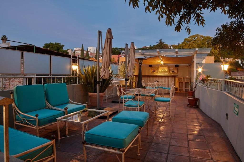 A rooftop terrace with outdoor seating, including chairs and tables, and a bar area.