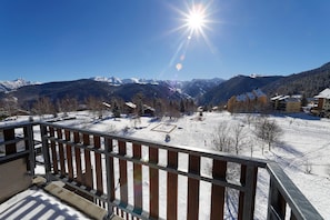 Un paysage enneigé, avec un ciel dégagé et des montagnes en arrière-plan.