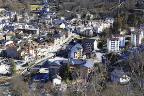 Ein Wohngebiet mit mehreren Mehrfamilienhäusern, einem Parkplatz und einer Brücke im Hintergrund.