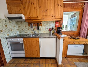 A kitchen with wooden cabinets, a stainless steel sink, a stove, and a dishwasher. - Apartment with large terrace and stunning views of the MatterhornOutside: apartment located on the g (St-Luc)