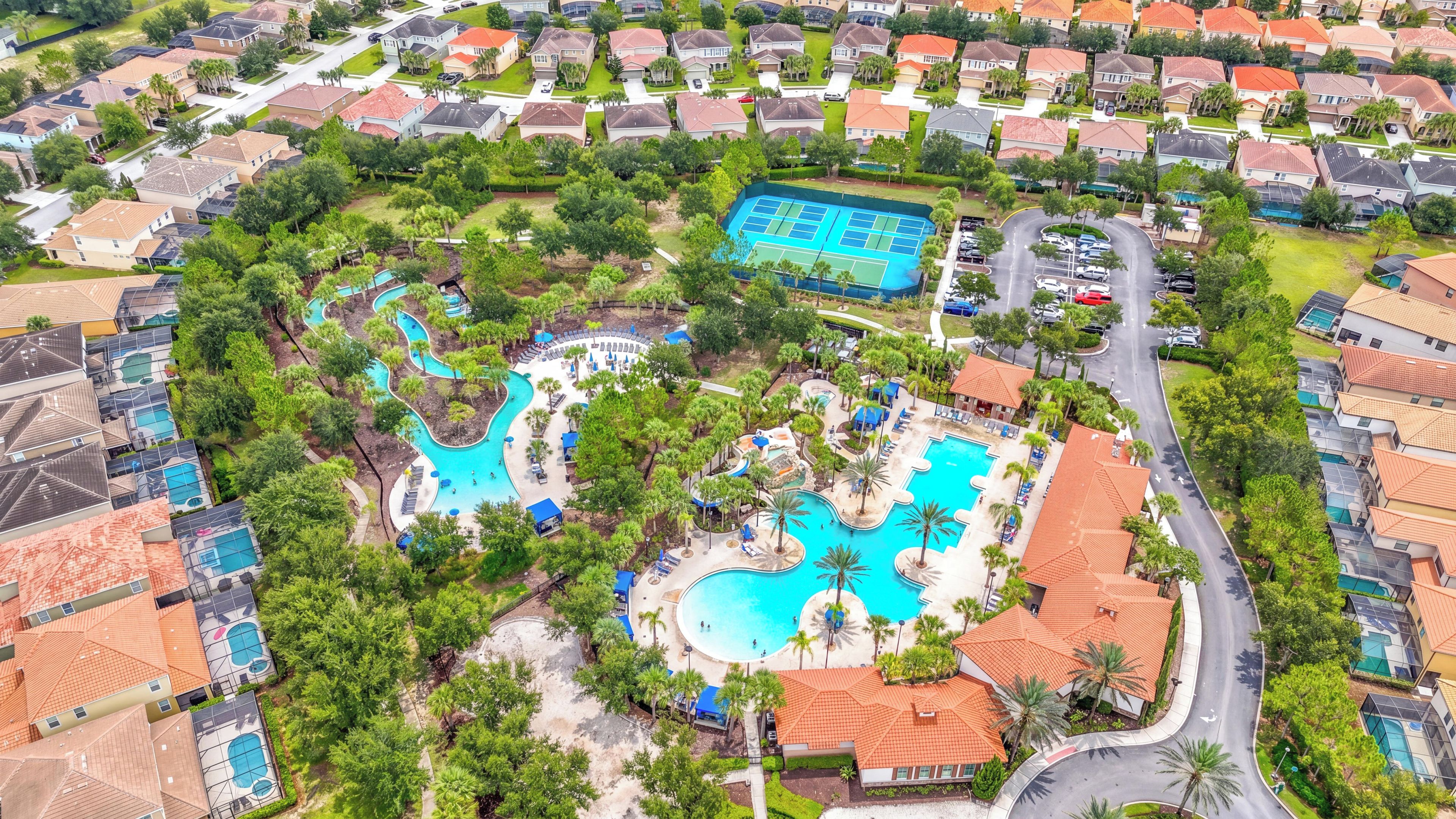An aerial view of a residential area with a large swimming pool surrounded by houses.