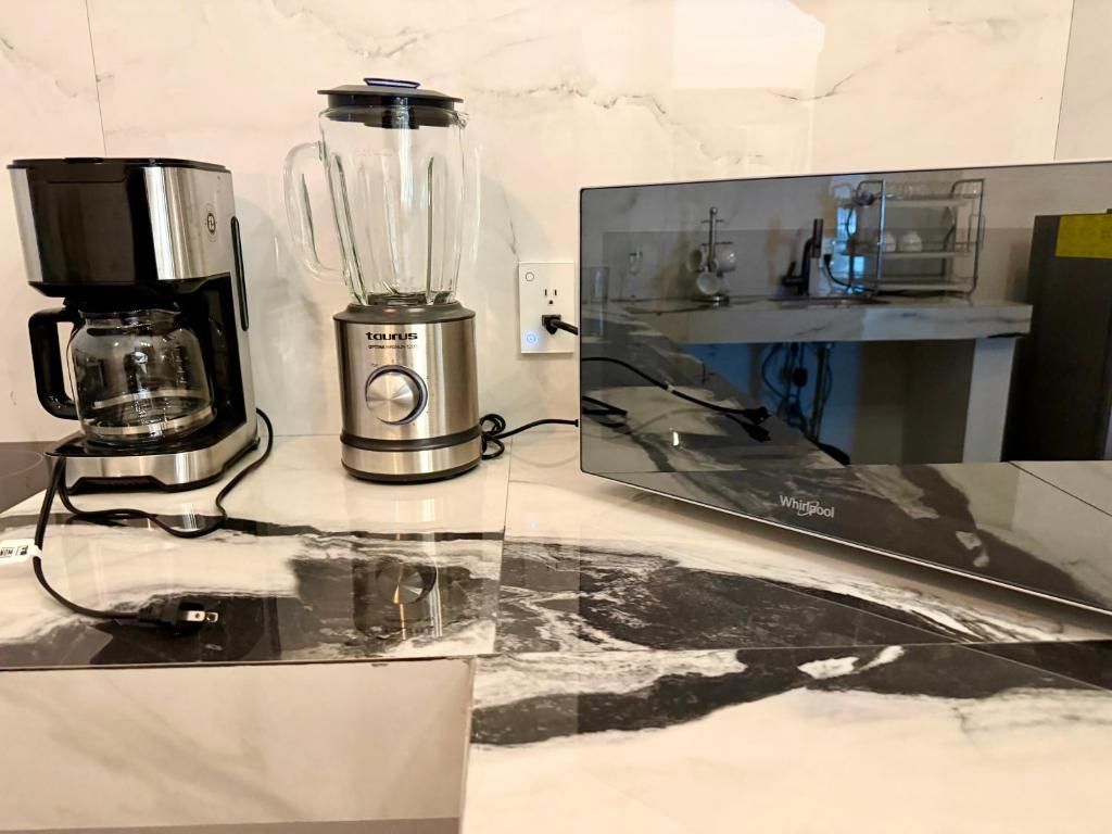 Una cocina con cafetera, licuadora y encimera.
