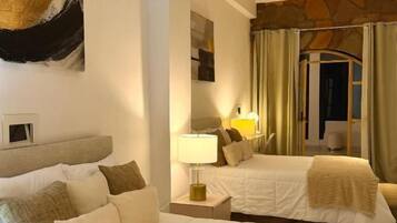 Una habitación de hotel con una cama grande, una mesita de noche con lámpara y un cuadro en la pared.
