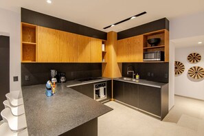 A modern kitchen with wooden cabinets, a microwave, and a sink. - Nice Apartment romantic zone close to the beach (Puerto Vallarta)