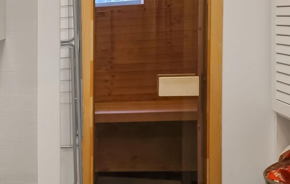 Una porta de fusta oberta amb un mànec metàl·lic i una placa rectangular petita.