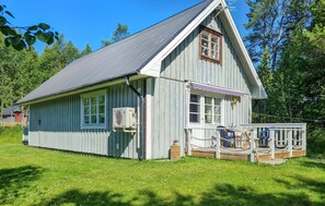 A single-story wooden building with a gabled roof, a front porch with a railing, and a small deck area. - Pet friendly home in Ljungdalen with sauna (Ljungdalen)