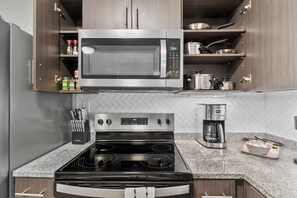A kitchen with a built-in microwave, stove, and coffee maker. - Endless Summer on the Warrior - Huntington Beach Meets Bama (Tuscaloosa)