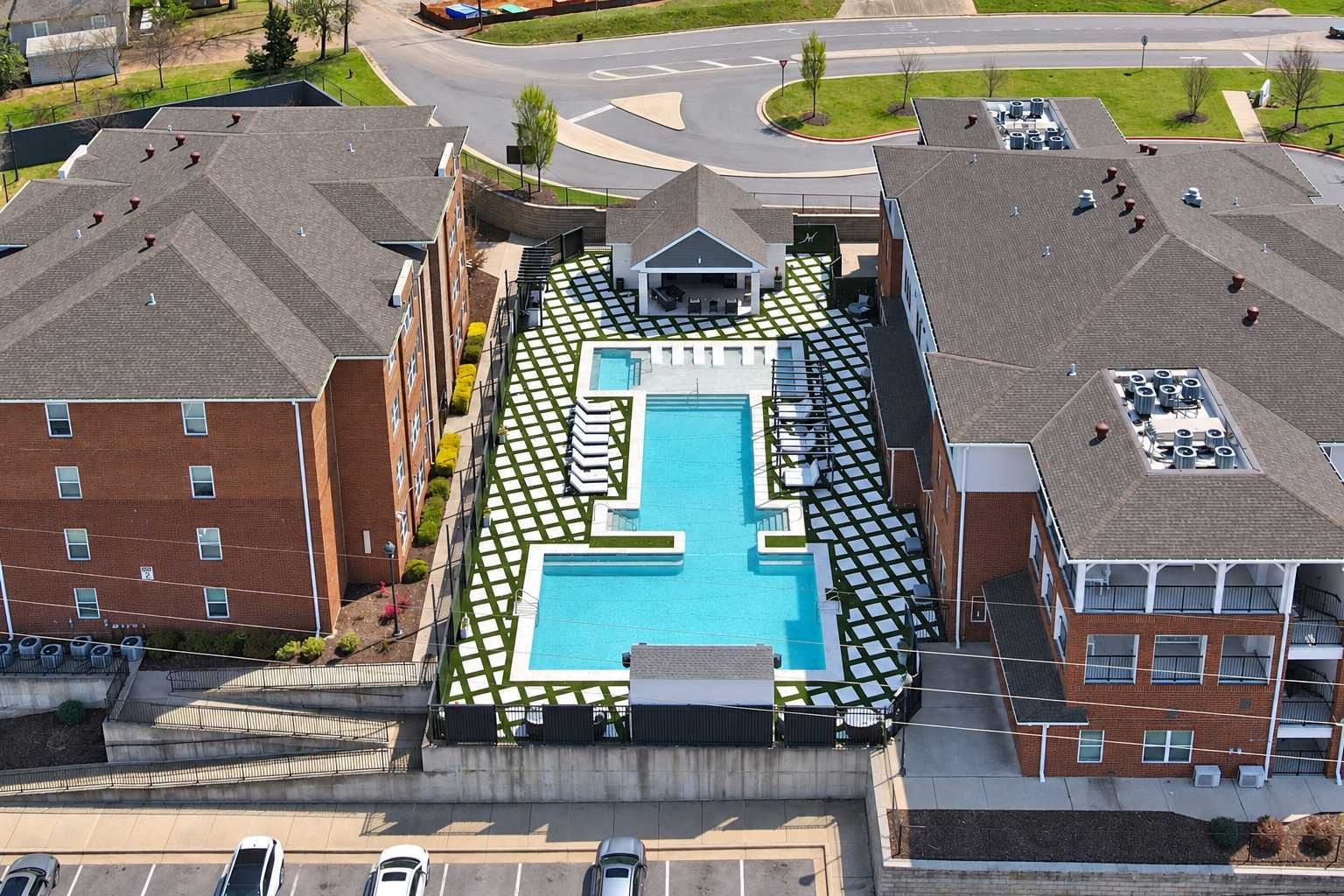 A rooftop swimming pool with a geometric design, surrounded by residential buildings.