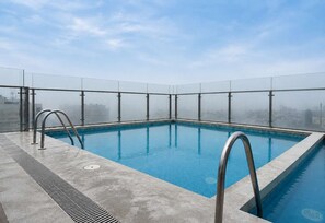 A rooftop infinity pool with clear glass railings and a cityscape view. - Loft con vista al mar y piscina Barranco (Barranco)