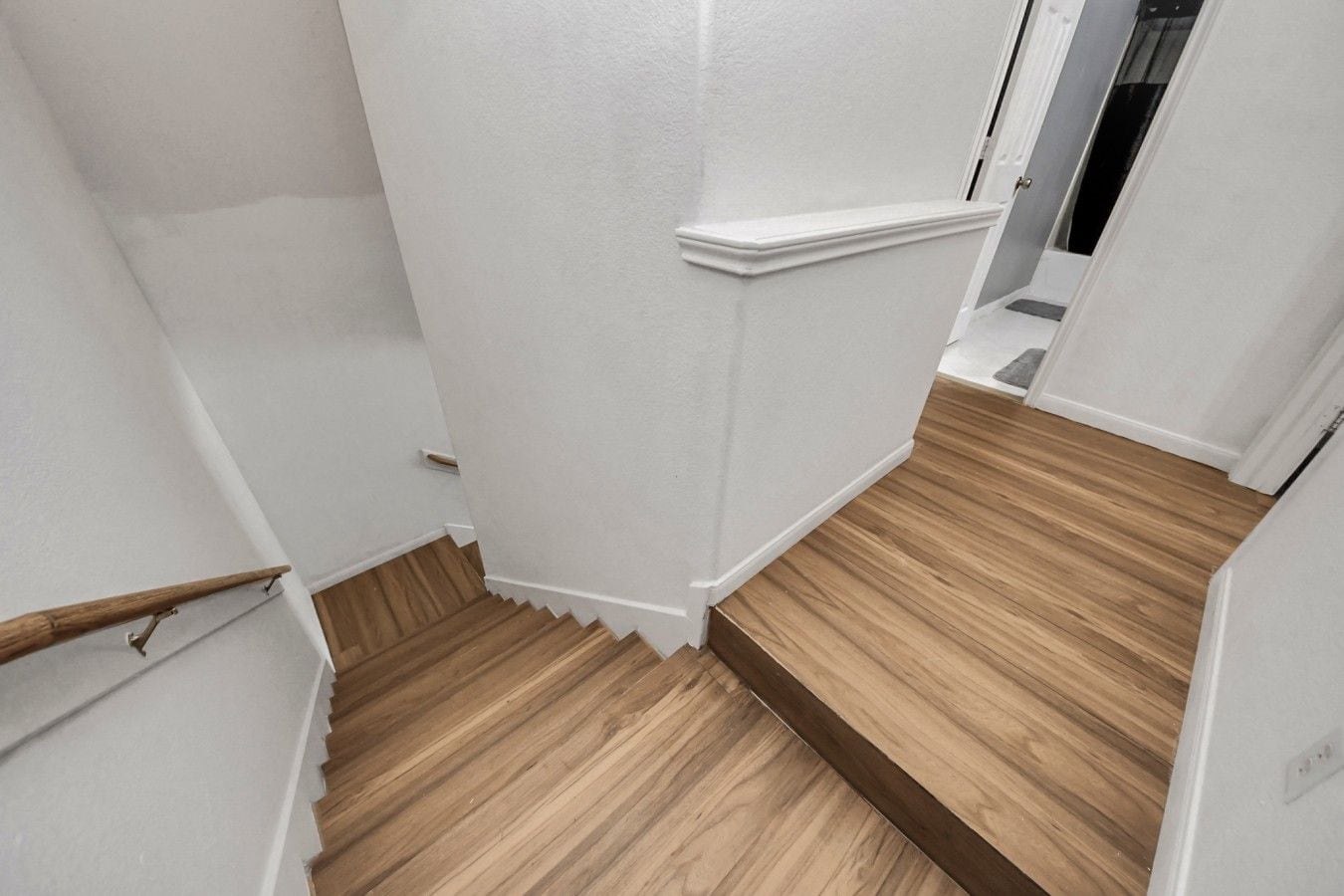 A staircase with wooden steps and white walls.