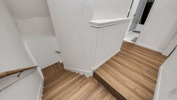 A staircase with wooden steps and white walls.