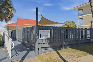 A gated clubhouse entrance with a sign indicating the direction to Sunset Harbour Villas. - Sunset Harbor 322 | Sound & Pool Getaway (Navarre)