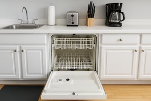 A kitchen with a dishwasher, a sink, a toaster, and a coffee maker. - Feel at Home in our 2BR Apt (Chicago)
