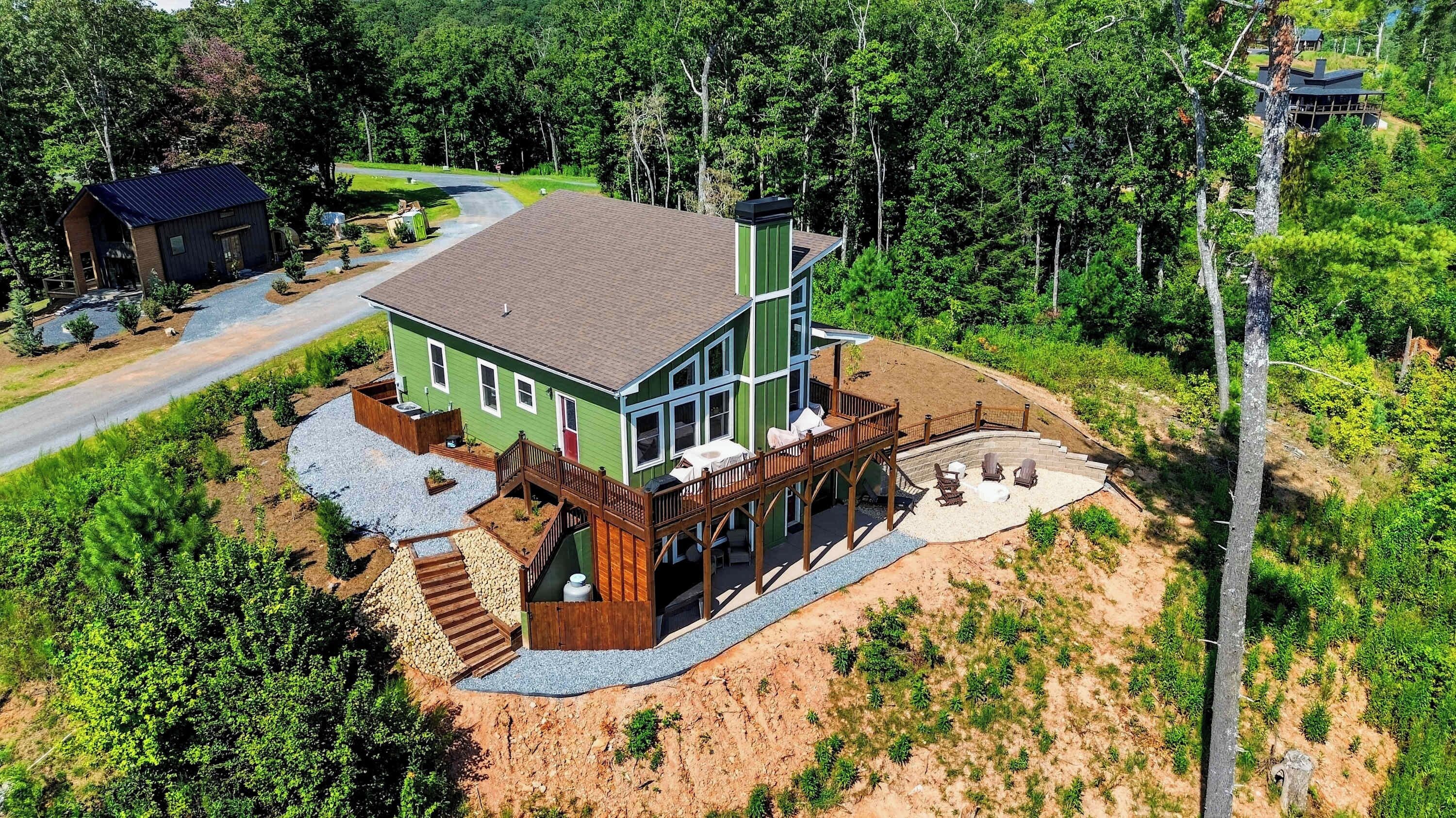 A two-story house with a deck, a covered patio, and a driveway.