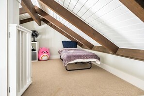 A child's bedroom with a bunk bed, a fan, a pink bear-shaped pillow, and a rainbow design. - Walk to Greek Peak Lifts - Mtn View & Balcony (Cortland)
