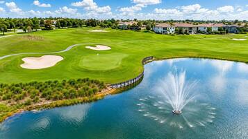 Un parcours de golf avec des bunkers, un étang agrémenté d’une fontaine et, au loin, des immeubles résidentiels.