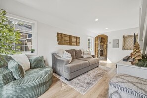 A modern living room with a grey sofa, a green armchair, and a patterned rug. - Big Pine House! Hot Tub + Dog Friendly + Fire Pit (South Lake Tahoe)