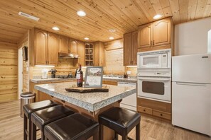 A kitchen with wooden cabinets, granite countertops, a refrigerator, a microwave, and a stove. - Big Pine House! Hot Tub + Dog Friendly + Fire Pit (South Lake Tahoe)