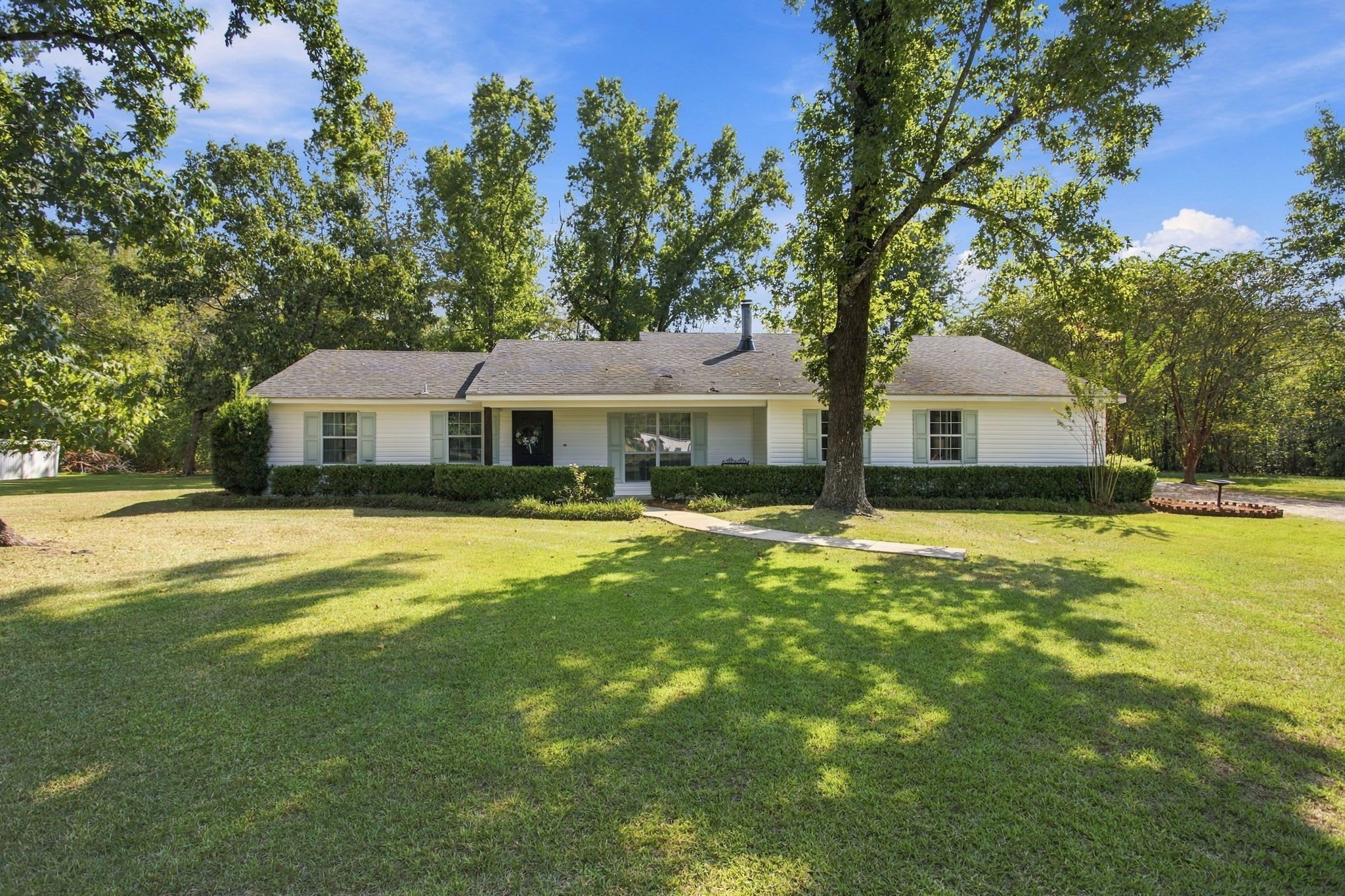 A single-story house with a front porch, a chimney, and a well-maintained lawn.