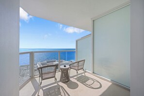 A balcony with a table and two chairs, overlooking a body of water. - Oceanview Studio at Fontainebleau Miami Beach with Balcony (Miami Beach)