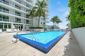 A swimming pool with a 3 ft no diving sign, surrounded by lounge chairs and palm trees. - Oceanview Studio at Fontainebleau Miami Beach with Balcony (Miami Beach)