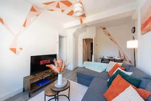 A modern living room with a sofa, a TV, and a decorative vase. - 2BR Maisonette | London Bridge | Near The Shard (London)